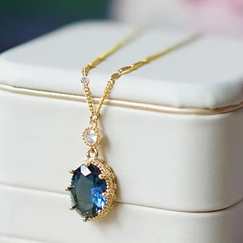 Gold necklace with oval sapphire pendant (teardrop style)
