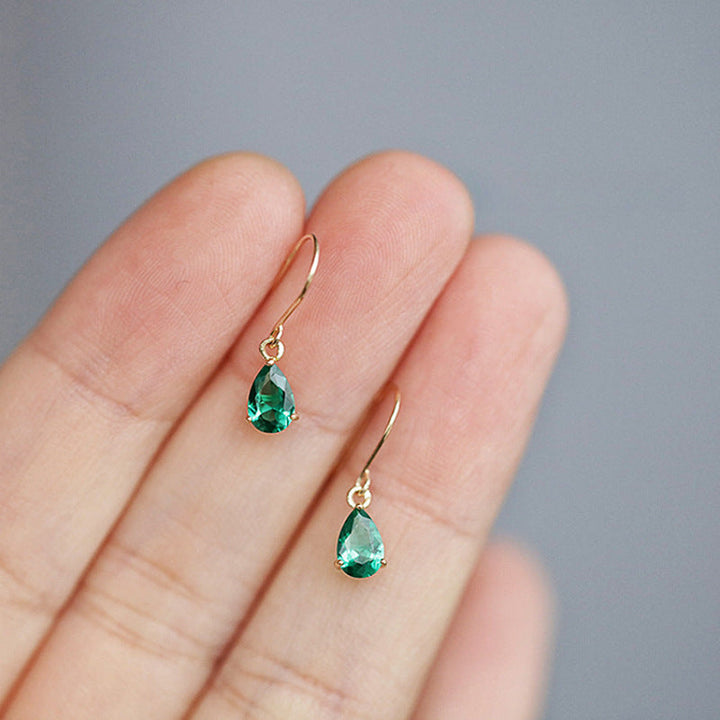 Gold drop earrings with teardrop-shaped emerald