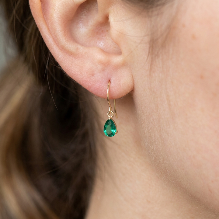 Gold drop earrings with teardrop-shaped emerald
